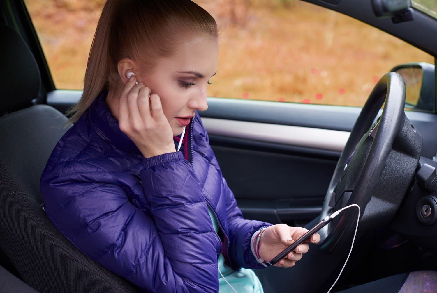 Women in a car wearing her headphones